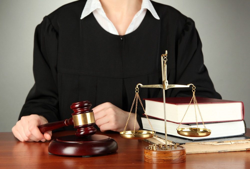 Female judge holding a wooden gavel.