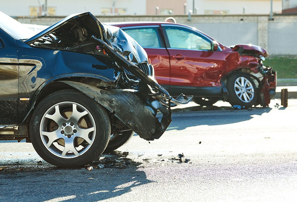 Two cars that have been in accidents, with their hoods horribly smashed up.