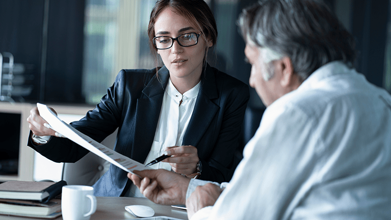 A female lawyer highlighting and emphasizing important details within a contract for a client.